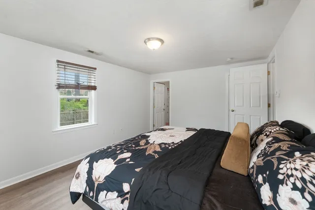 a bed sitting in a bedroom next to a window