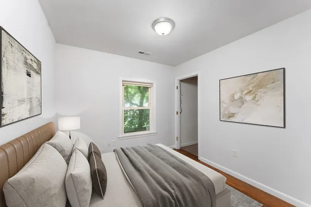 a bed room with a bed and a painting on the wall