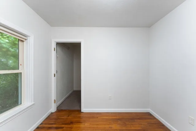 a view of a room with wooden floor and a window