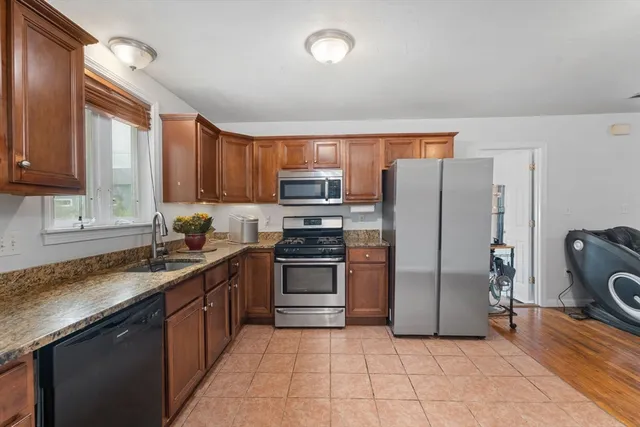 a kitchen with stainless steel appliances granite countertop a stove a sink dishwasher a refrigerator and a microwave oven