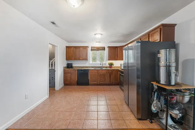 a kitchen with stainless steel appliances granite countertop a refrigerator and a stove