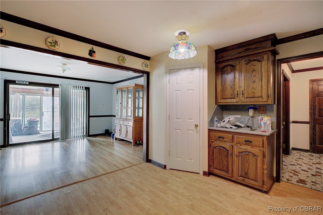 2488 Winfred Road Hayes, VA 23072 - Photo 9 of 25 Kitchen featuring light wood-type flooring, crown molding, and decorative backsplash