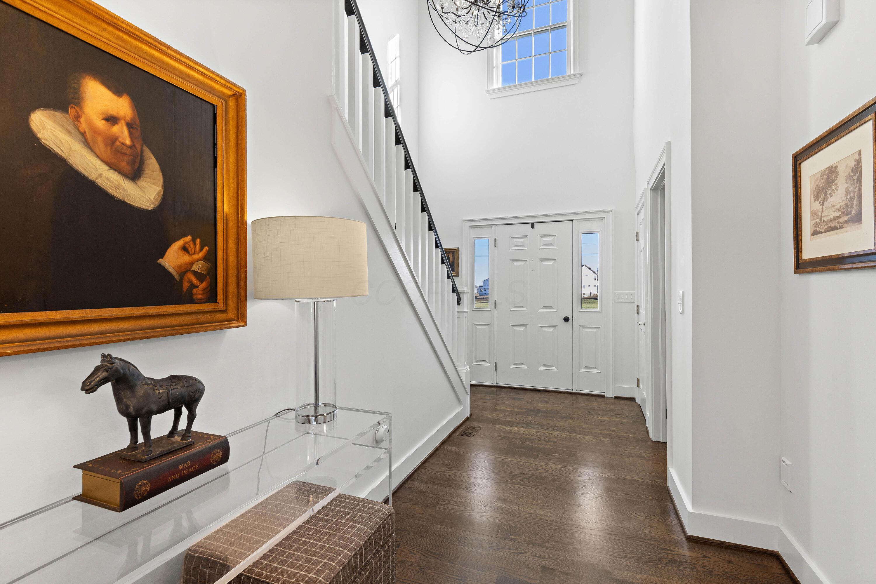1364 Dale Ford Road Delaware, OH 43015 - Photo 6 of 112 • Hardwood flooring • White painted walls • Two-story ceiling • Coat closet • Chandelier • Sidelights by front door • New staircase
