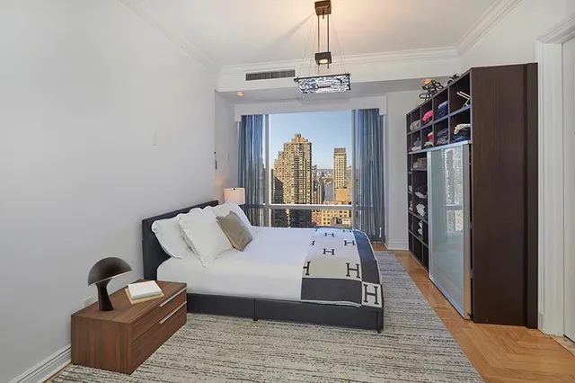 a bed sitting in a spacious bedroom next to a window