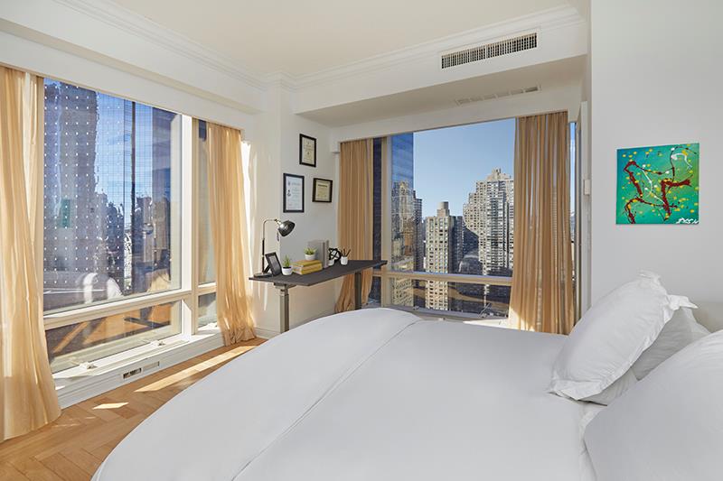 1 Central Park West, Unit 40CD Manhattan, NY 10023 - Photo 9 of 15 a bedroom with furniture and large windows