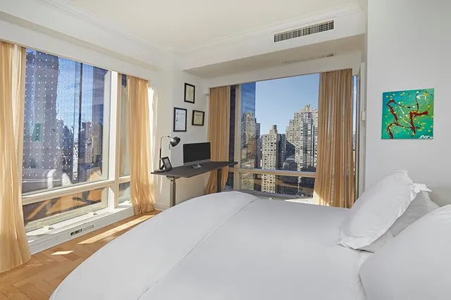 a bedroom with furniture and large windows