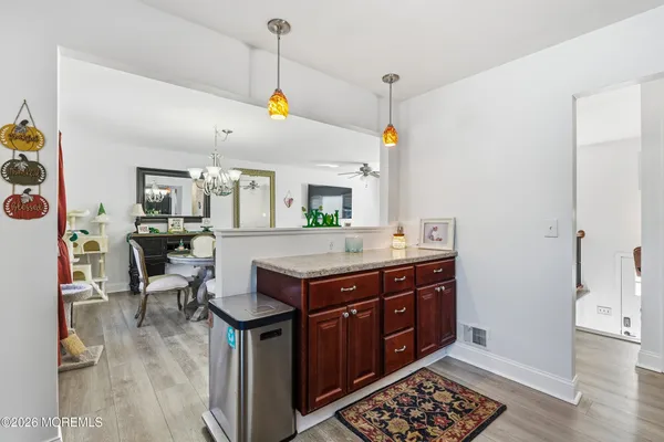 a kitchen with stainless steel appliances granite countertop a stove a sink dishwasher and a dining table with wooden cabinet