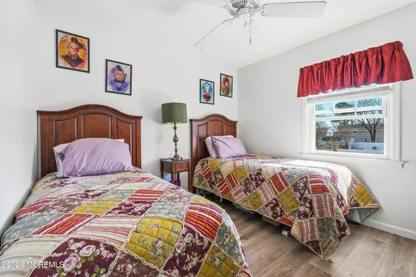 a bedroom with two beds and a painting on the wall