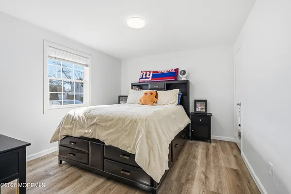 a bedroom with a bed and a dresser next to a window