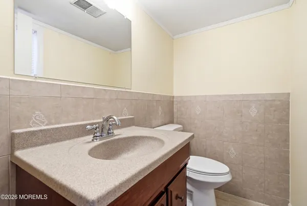 a bathroom with a sink toilet and a mirror
