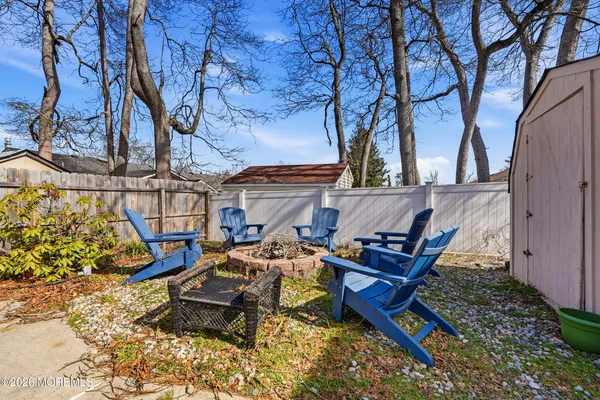 a sitting area with some trees in front of it