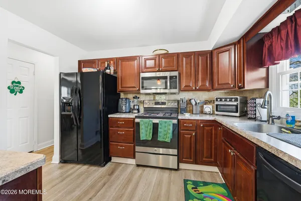 a kitchen with stainless steel appliances granite countertop a refrigerator stove and sink