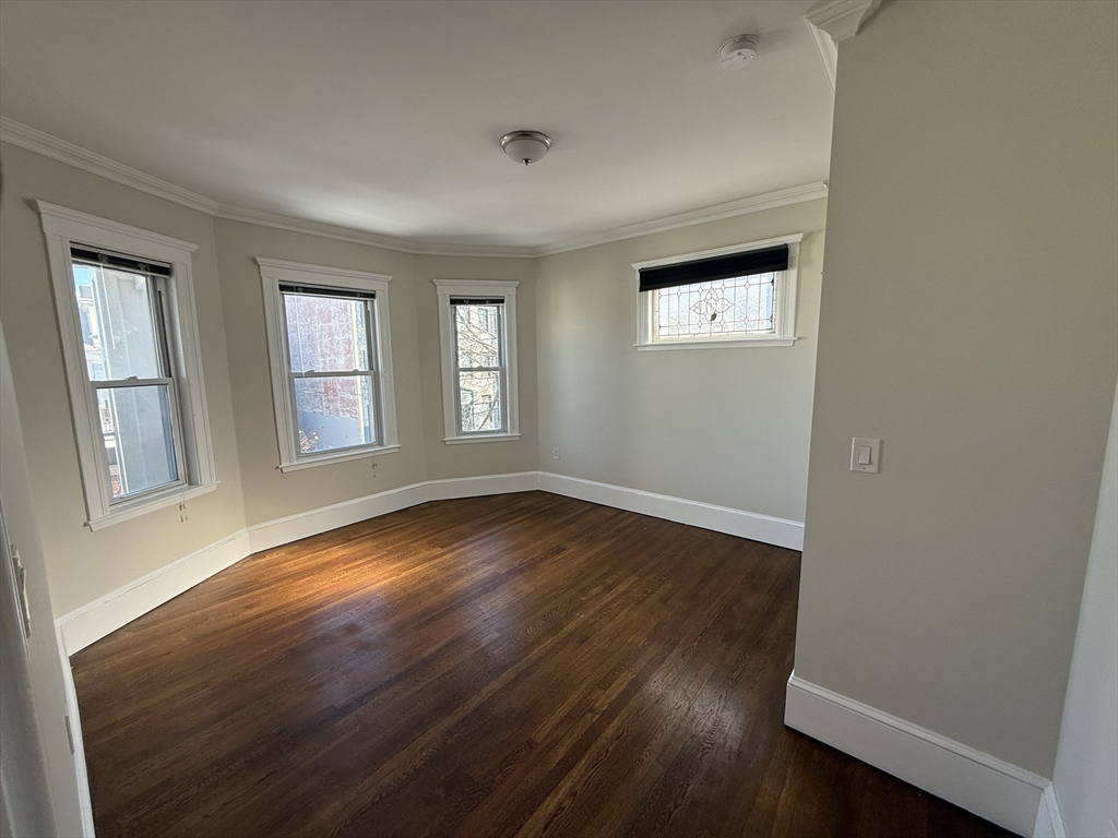 55 Iffley Road, Unit 3 Boston, MA 02130 - Photo 11 of 12 an empty room with wooden floor and windows