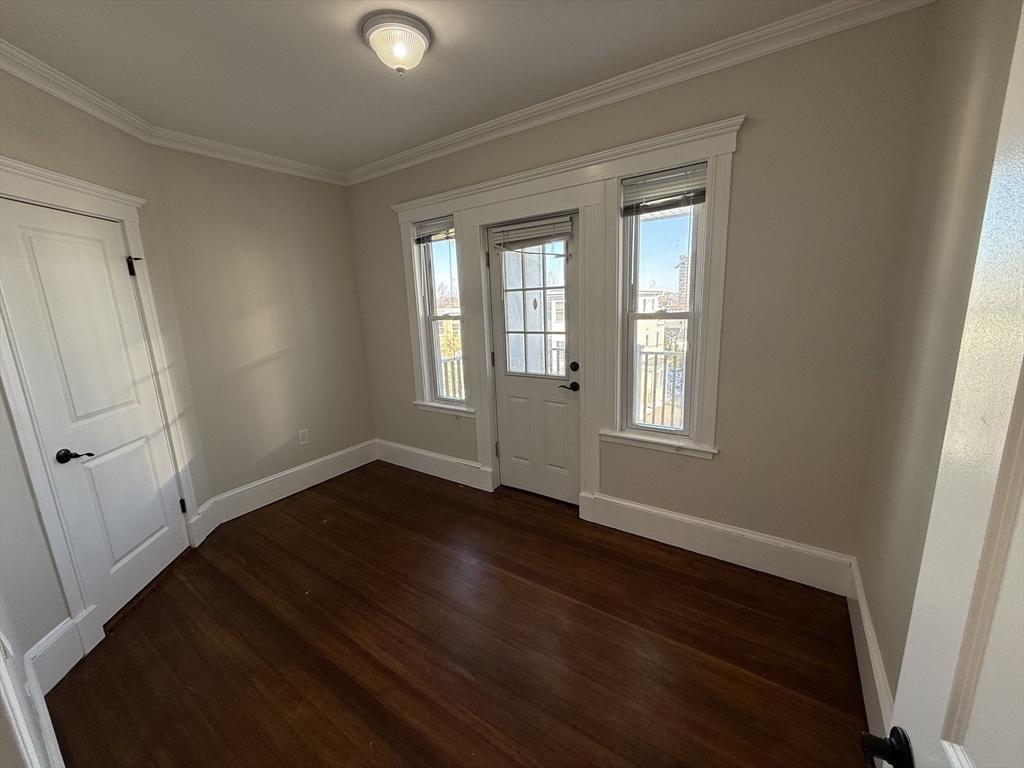 55 Iffley Road, Unit 3 Boston, MA 02130 - Photo 12 of 12 a view of an empty room with wooden floor and a window