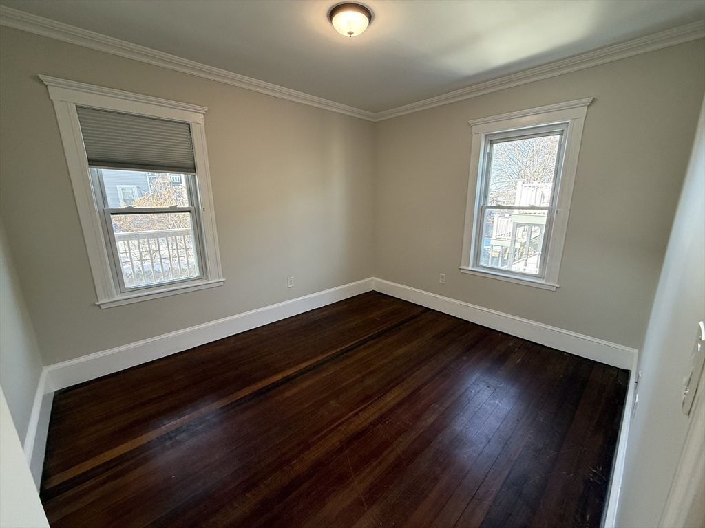 55 Iffley Road, Unit 3 Boston, MA 02130 - Photo 4 of 12 a view of an empty room with wooden floor and a window