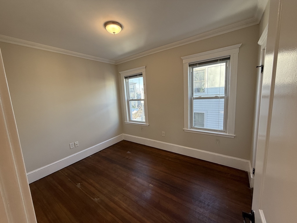 55 Iffley Road, Unit 3 Boston, MA 02130 - Photo 9 of 12 a view of an empty room with wooden floor and a window