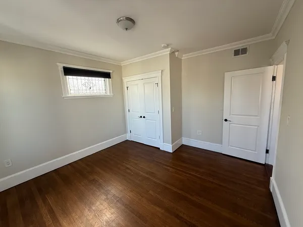 a view of an empty room with wooden floor