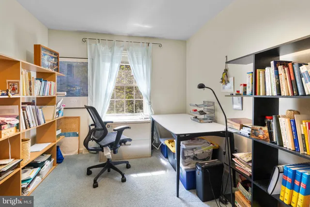 a view of a workspace with furniture and a window
