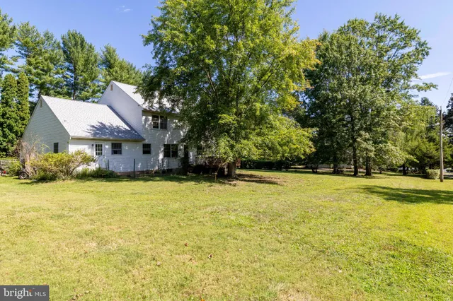 a front view of house with outdoor space and trees all around