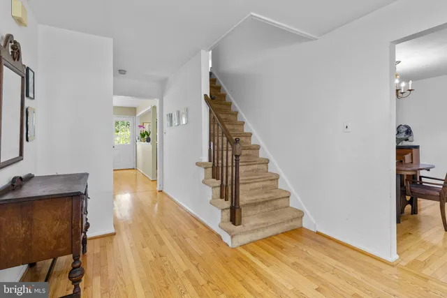 a view of a hallway with wooden floor and staircase
