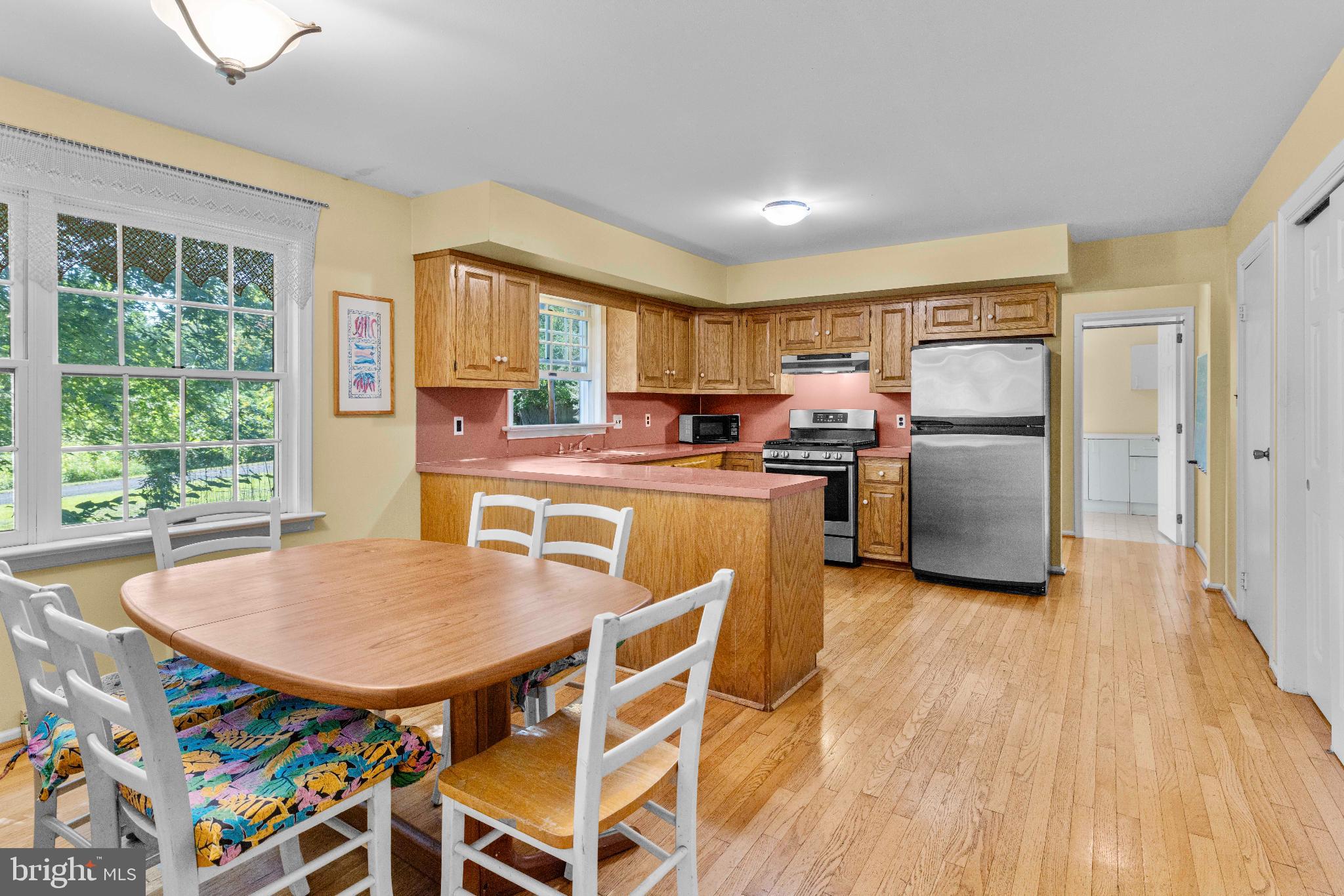 1478 Dillon Road Ambler, PA 19002 - Photo 10 of 42 a kitchen with stainless steel appliances granite countertop a stove a refrigerator a microwave a dining table and chairs with wooden floor