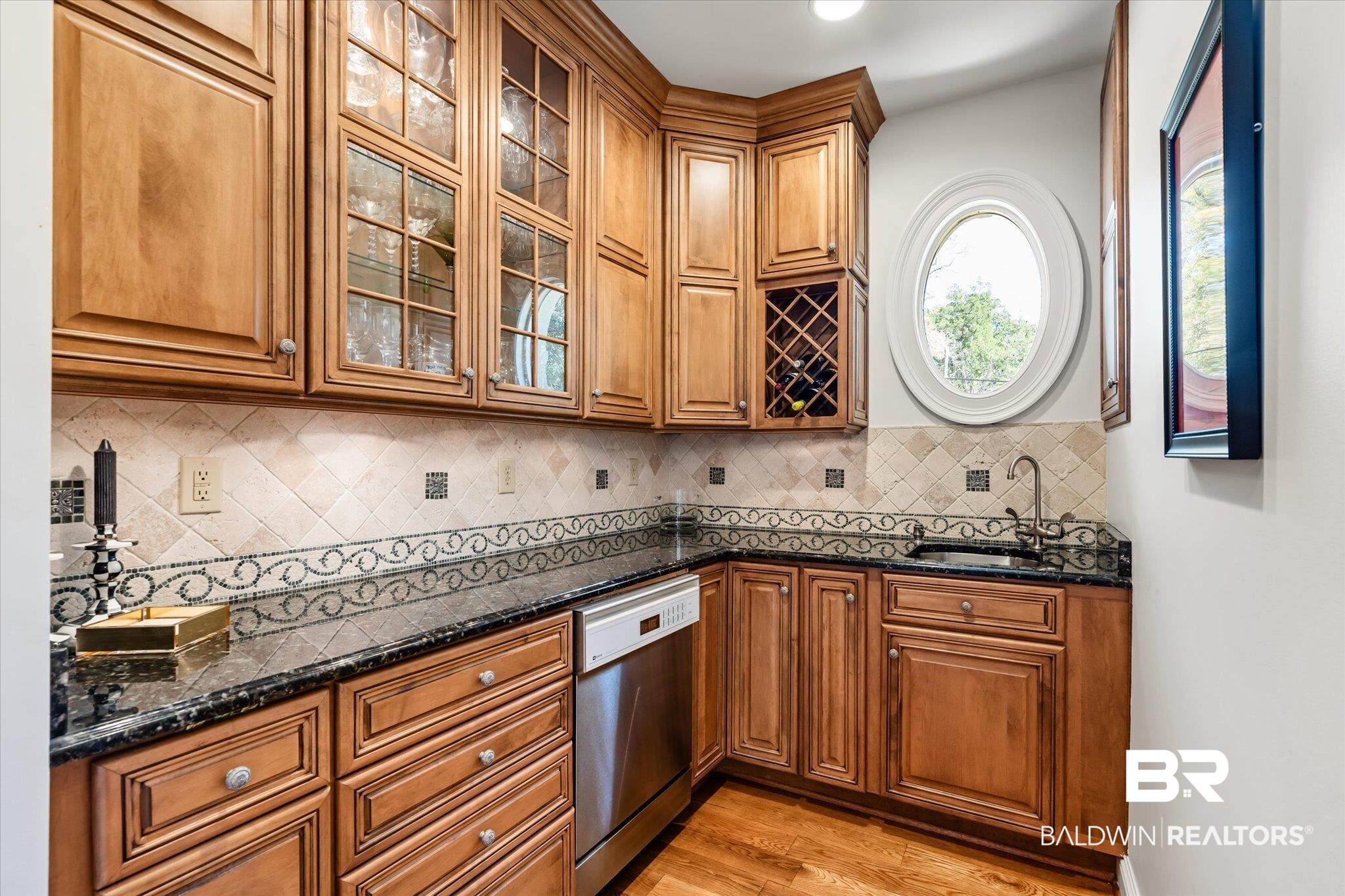 4 Kingsway Mobile, AL 36608 - Photo 12 of 44 Kitchen with a sink, dark stone counters, brown cabinets, and dishwasher