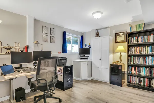 a view of a workspace with furniture and a bookshelf