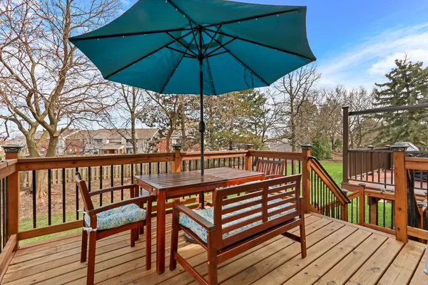 a view of a roof deck with table and chairs under an umbrella