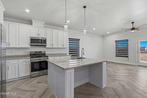 a view of kitchen with stainless steel appliances cabinets and window