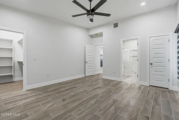 an empty room with a ceiling fan and window