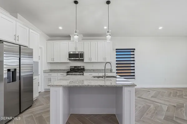 a kitchen with kitchen island a oven a chimney and a counter top space