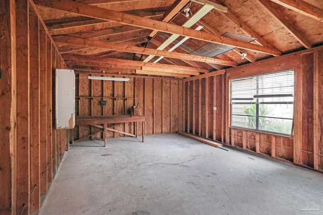 a view of an empty room with furniture and a window