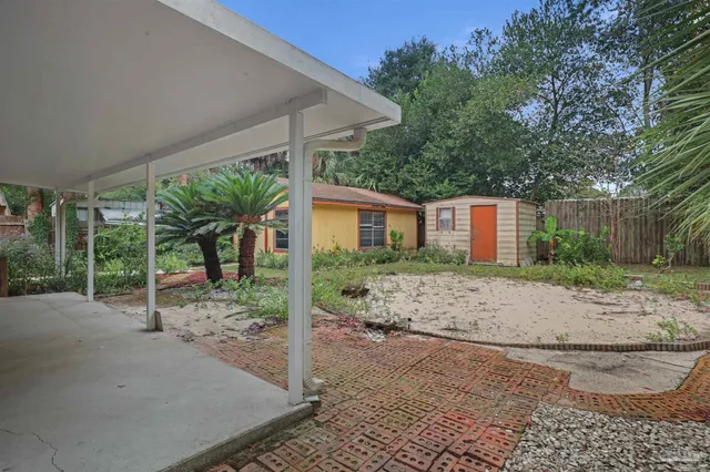a view of a house with a yard and potted plants