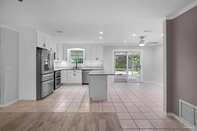 a kitchen with a sink a counter top space stainless steel appliances cabinets and a window
