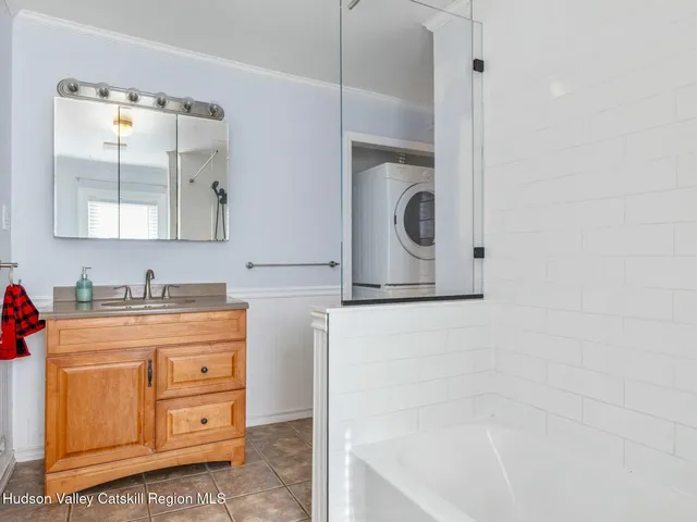 a bathroom with a granite countertop sink a mirror and a bathtub