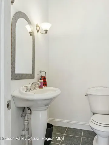 a bathroom with a sink toilet and a mirror