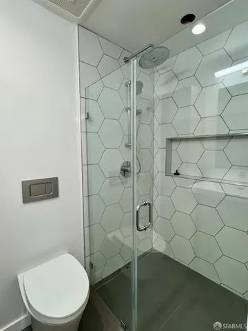 a white toilet sitting next to a shower