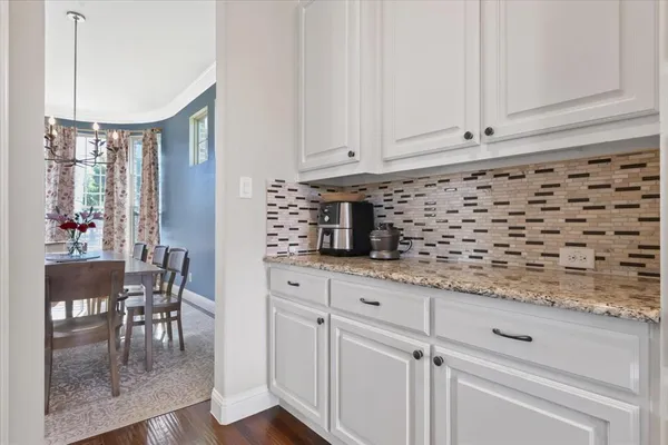 a kitchen with granite countertop white cabinets and white appliances