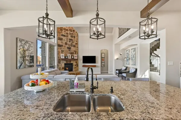 a kitchen with a sink a chandelier and living room view