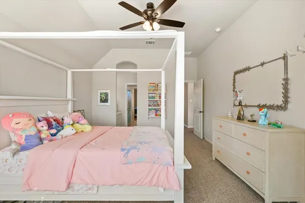 a bedroom with a bed and a chandelier fan