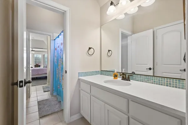 a en suite bathroom with a sink a mirror and a shower