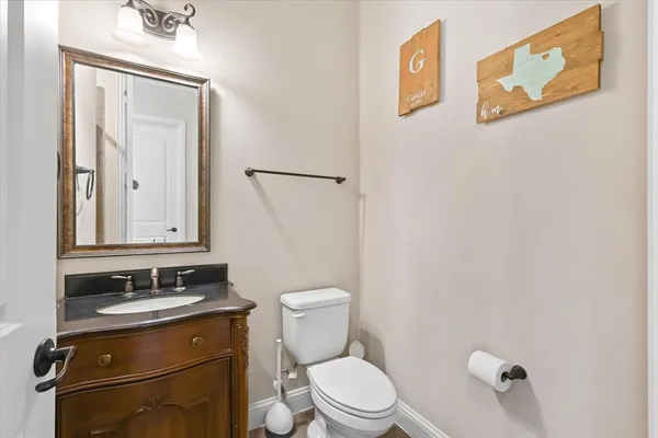 a bathroom with a toilet sink vanity and mirror
