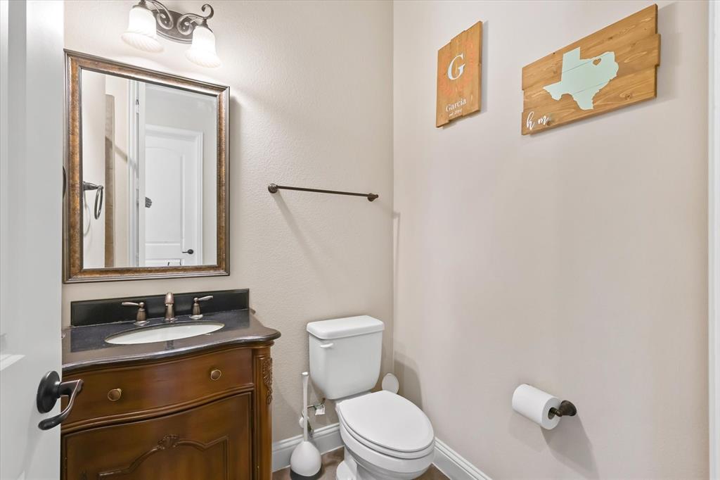 14006 Stars Road Frisco, TX 75035 - Photo 32 of 38 a bathroom with a toilet sink vanity and mirror