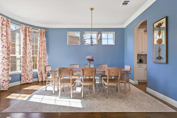 a dining room with wooden floor a glass table and chairs