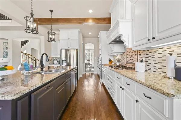 a large kitchen with granite countertop a sink and cabinets