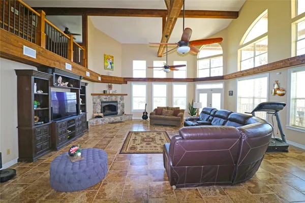 a living room with furniture a fireplace and a large window