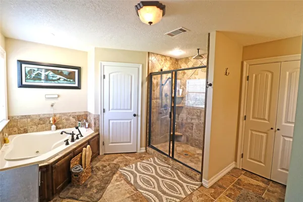 a bathroom with a granite countertop sink a mirror and a shower