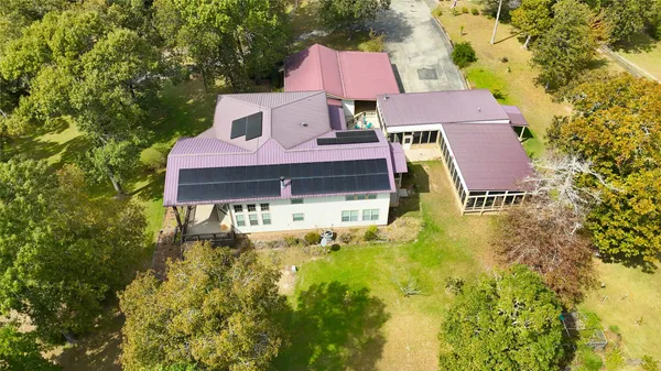 a aerial view of a house with pool and trees