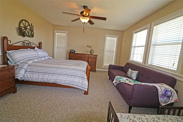 a spacious bedroom with a bed and a chandelier