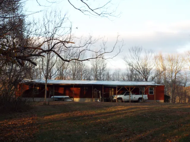 a view of a large house with a road and a large tree